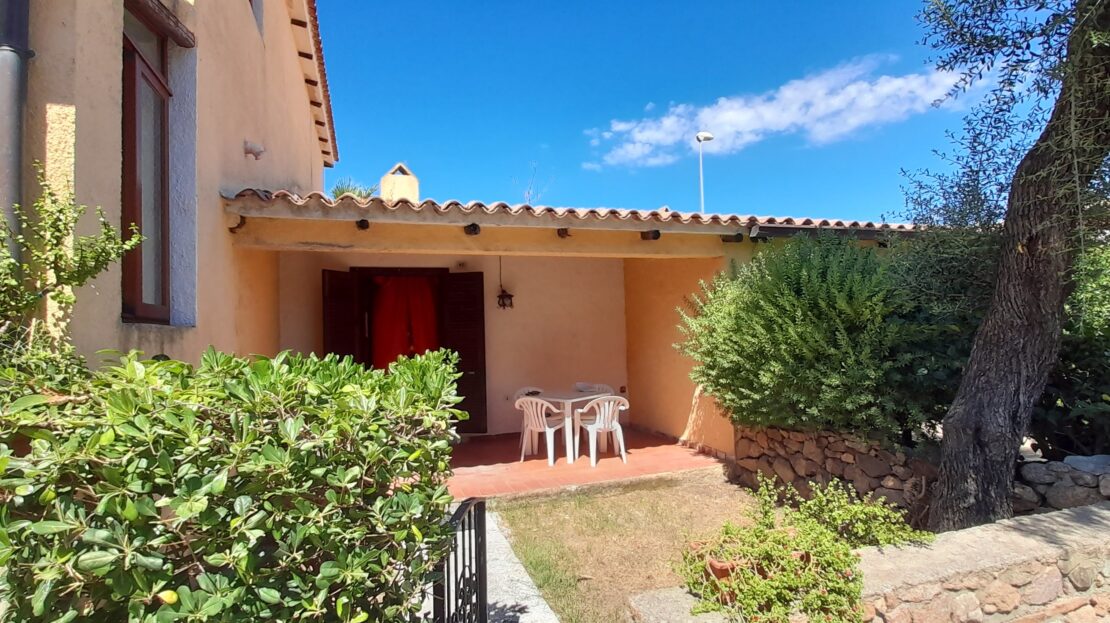 ingresso di un appartamento dal giardino con patio e sedie esterne